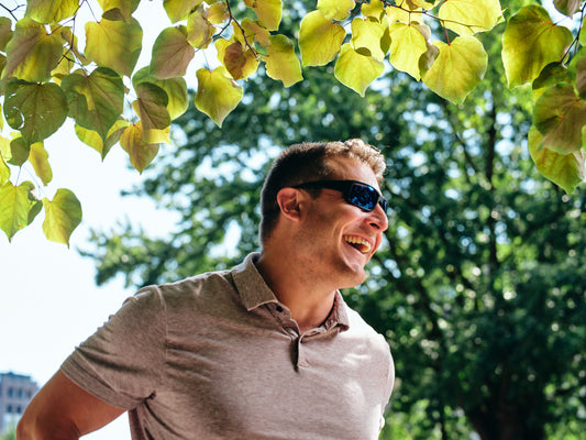 Image of a man smiling outside wearing sunglasses.