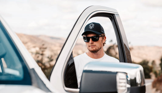 Image of a man wearing sunglasses standing outside of his truck.