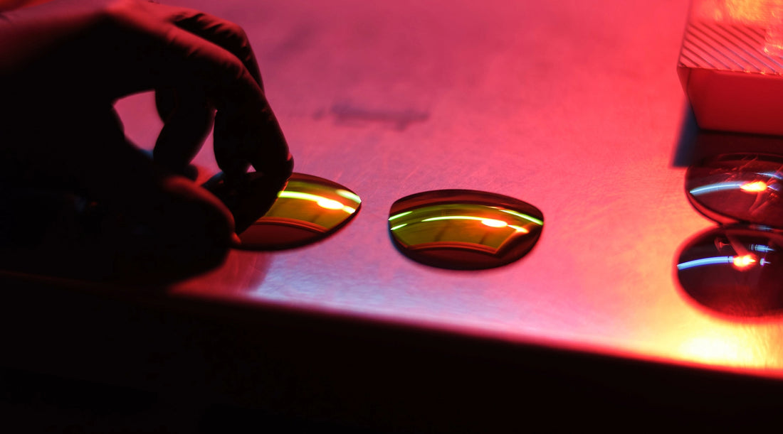 Image of sunglass lenses sitting on a table in a technical, lab-like environment.