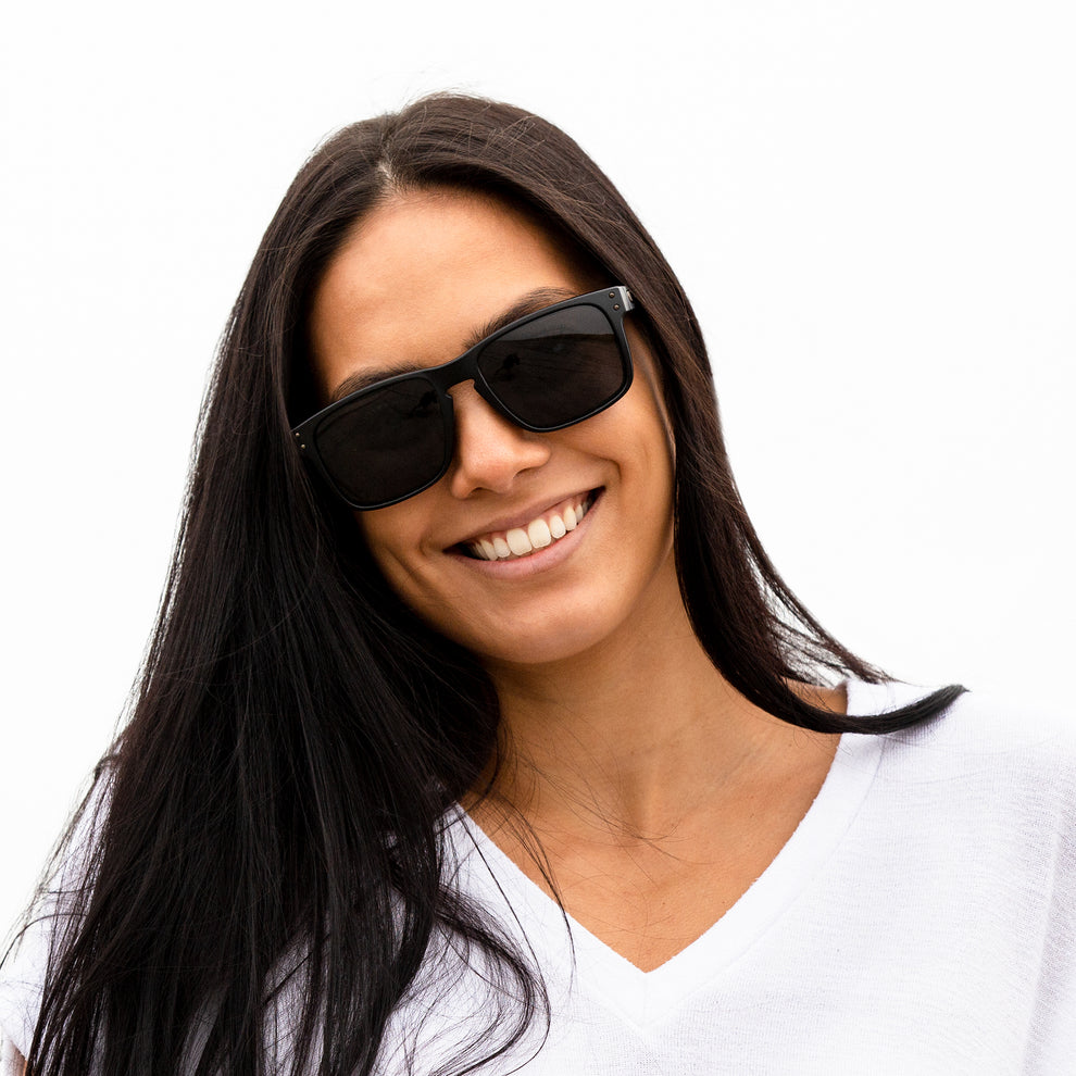 A person wearing sunglasses with Polarized Stealth Black lenses installed in the frame