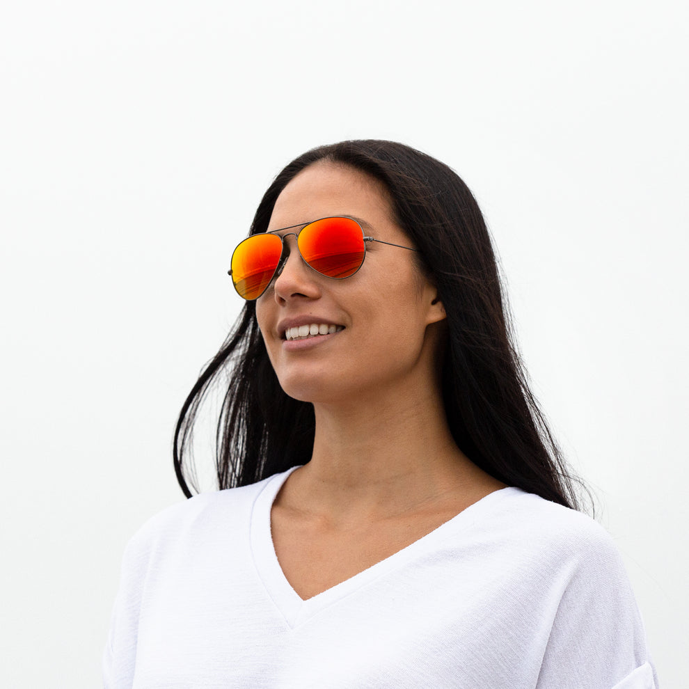 A person wearing sunglasses with Polarized Fire Red lenses installed in the frame